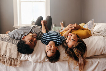 Happy family having fun together in their bedroom