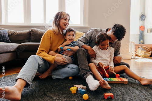 Young parents having fun with their children at home photo