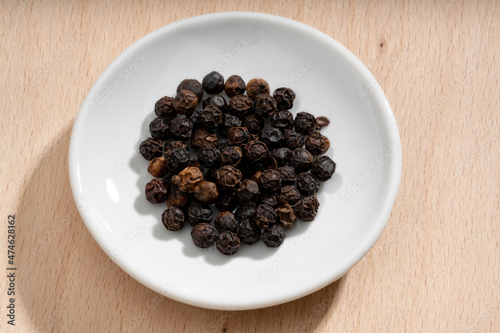 Detailed and large close up shot of peppercorns on a small plate Detailed and large close up shot of peppercorns on a small plate