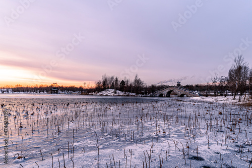 Winter scenery of the North Lake National Wetland Park in Changchun, China under the sunset