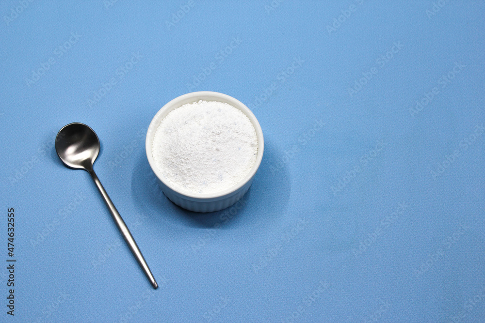 Collagen powder on blue background. Natural health supplement for skin Collagen powder on blue background. Natural health supplement for skin