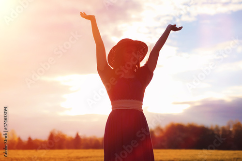 Young beautiful girl in dresses on nature. A girl in a hat walks in the park. Young woman on a picnic with a basket outside the city.