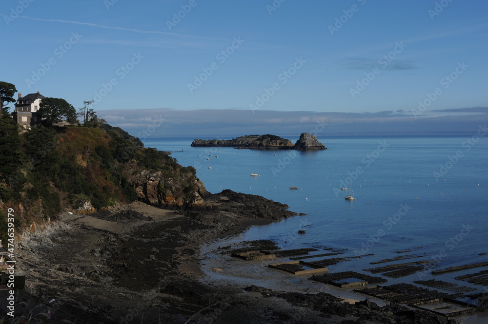 Oyster farm during low tide with blue sky and sea in Cancale, Normandy, France
