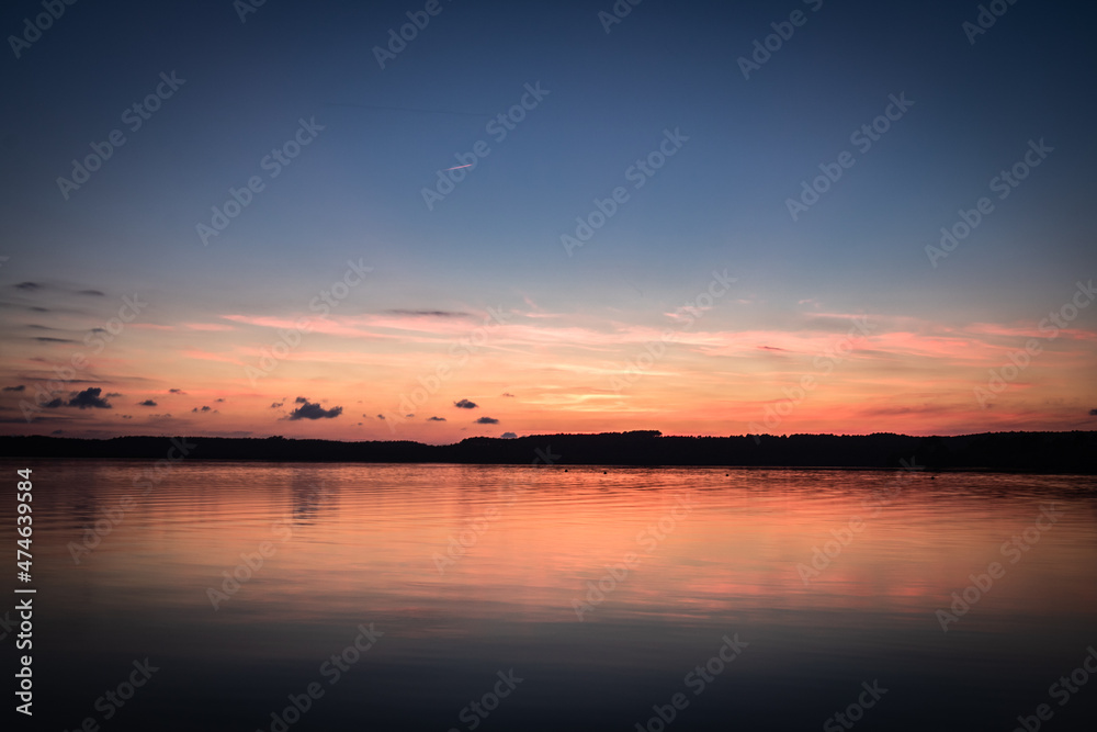 Beautiful sunset on the lake, reflection of clouds and moon, background Beautiful sunset on the lake, reflection of clouds and moon, background