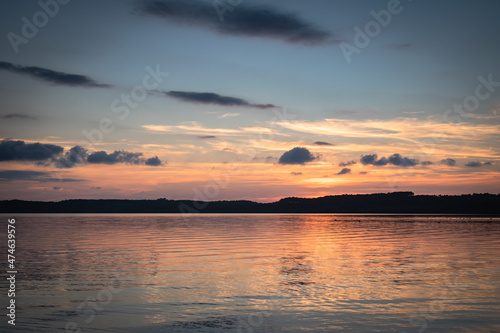 Beautiful sunset on the lake, reflection of clouds and moon, background