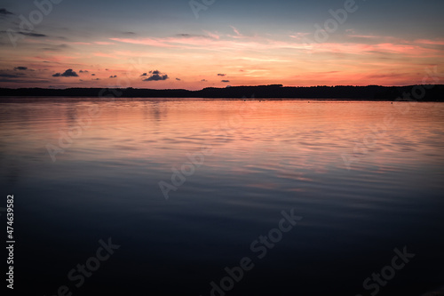Beautiful sunset on the lake  reflection of clouds and moon  background