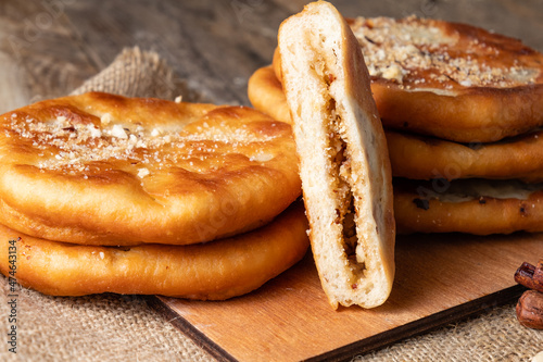 Korean pancakes stuffed with nuts, sugar and cinnamon. Hotteok on a wooden table. photo