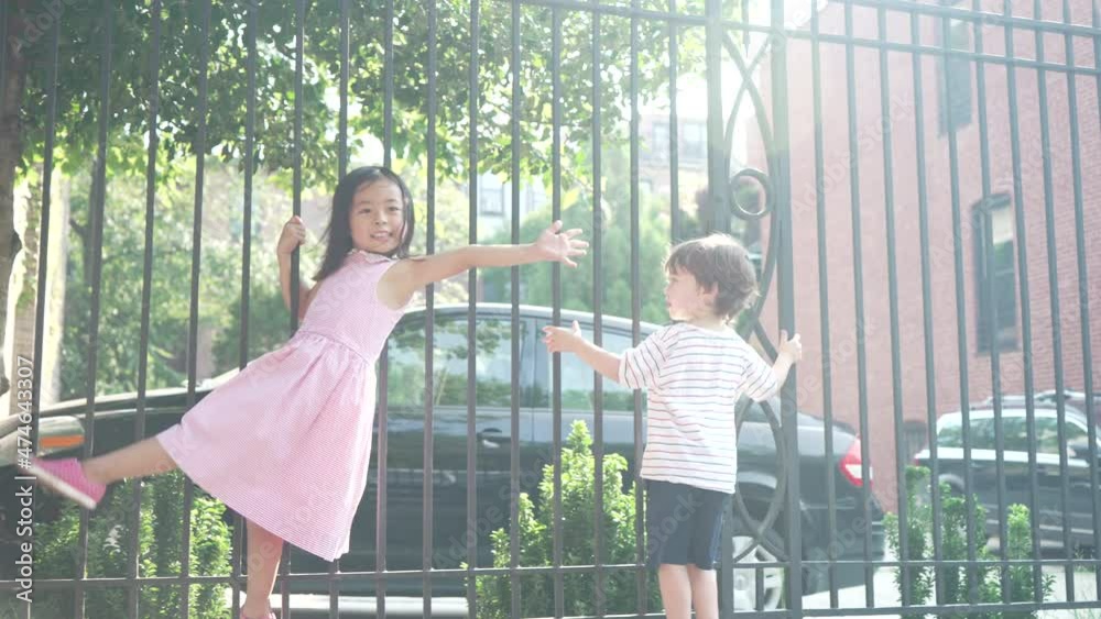 slow motion shot of a little boy and a little girl playfully hanging on ...