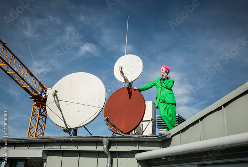 Businesswoman talking on mobile phone at satellite dish