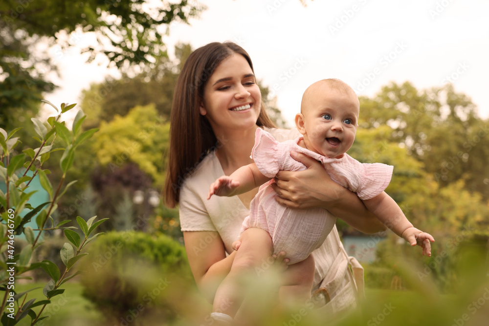 Happy mother with adorable baby walking in park on sunny day Happy mother with adorable baby walking in park on sunny day