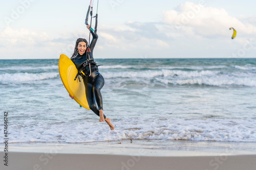 Cheerful woman with kiteboard surfing at beach photo