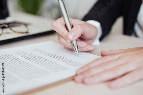 Real estate agent signing document at office
