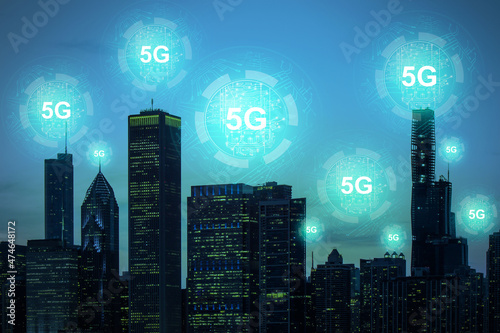 Creative dark night city background with glowing 5G circuit hologram. Internet speed, ubanization, communication and connection concept. Double exposure. photo
