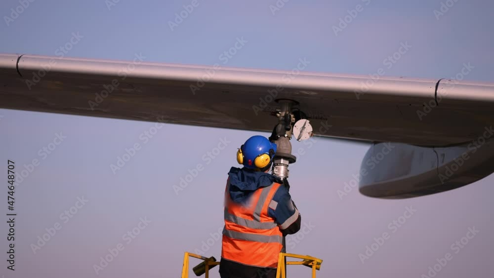 Airport airplane crew refueling aircraft on airline by technical staff maintenance ground. Preparing airplane for departure. repair of aircraft service worker use fuel hose on aircraft wing, on stairs