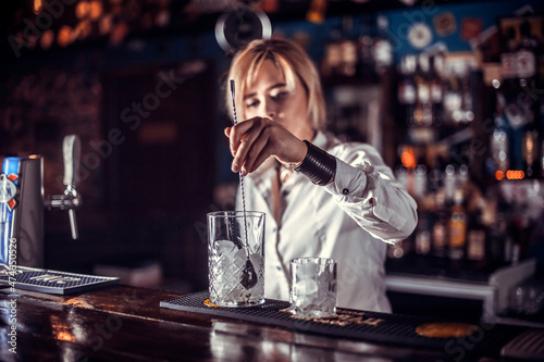 Girl barman formulates a cocktail on the beerhouse photo