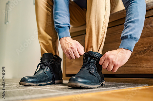 The man is wearing shoes. Close up of a man's feet in boots. A man prepares to go out.