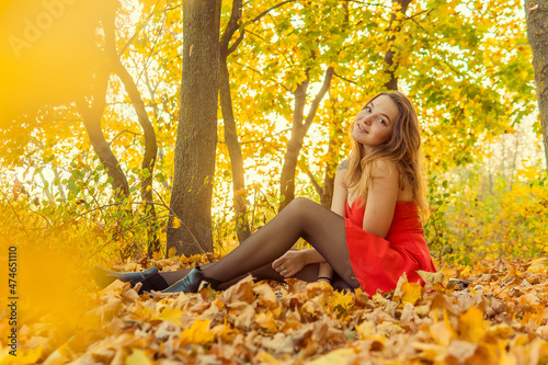 A woman is posing in front of a camera in an autumn park. autumn photo shoot. Autumn in the park.