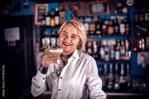 Experienced woman bartending demonstrates his skills over the counter on the bar photo