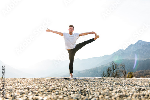 Man practicing Utthita Hasta Padangusthasana with mountain view photo