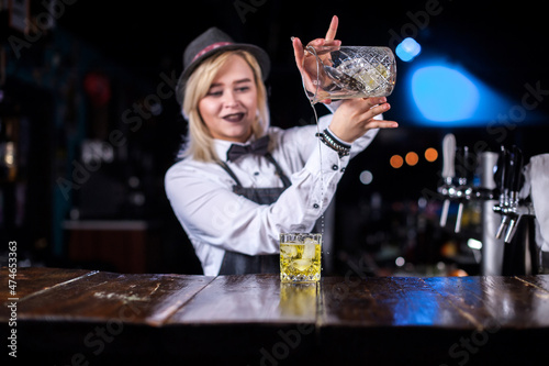 Girl barman concocts a cocktail at the pothouse photo