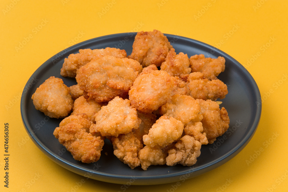 A plate of fried chicken with yellow background A plate of fried chicken with yellow background