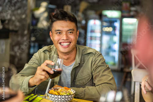 Foto Portrait of an happy asian man at restaurant, smiling person having fun at dinne