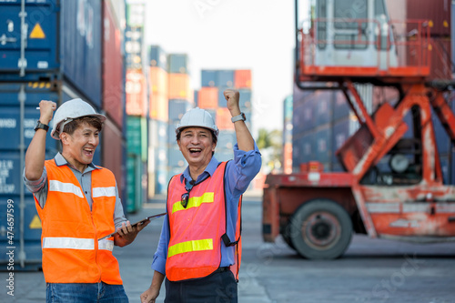 Container cargo foreman partners successful happy together into container for loading. Celebrating success. Group of worker looking happy at their working places in container cargo site.