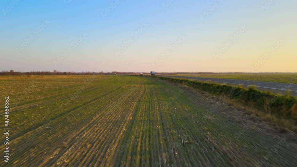 Aerial view of intercity road with fast driving cars at sunset. Top view from drone of highway traffic in evening Aerial view of intercity road with fast driving cars at sunset. Top view from drone of highway traffic in evening