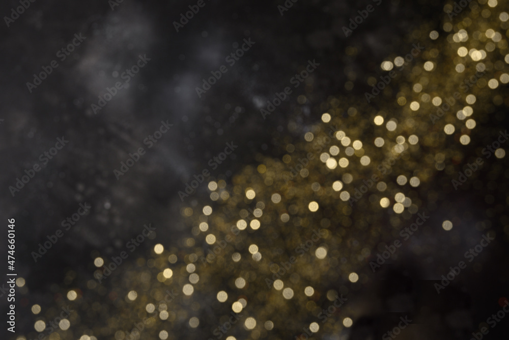 Christmas gold shine sparkles or glitter on black background. Xmas festive abstract pattern.