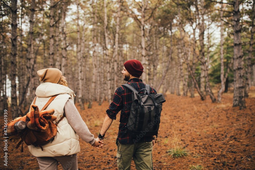 Couple in love hiking together in a forest. Millennial hipsters travelers spending time together. Couple in love hiking together in a forest. Millennial hipsters travelers spending time together.