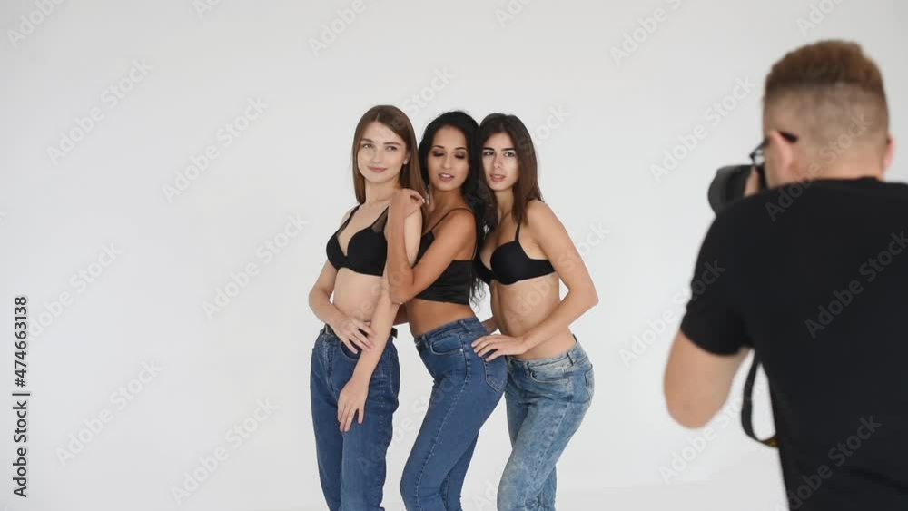 Three young women in bra and jeans together posing for the photographer