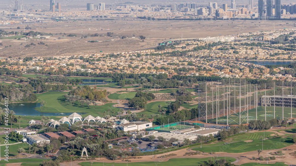 Aerial view to Golf course with green lawn and lakes, villa houses behind it timelapse.