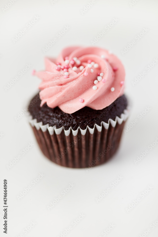 Kleiner Cupcake mit rosa Himbeercreme als Dekoration