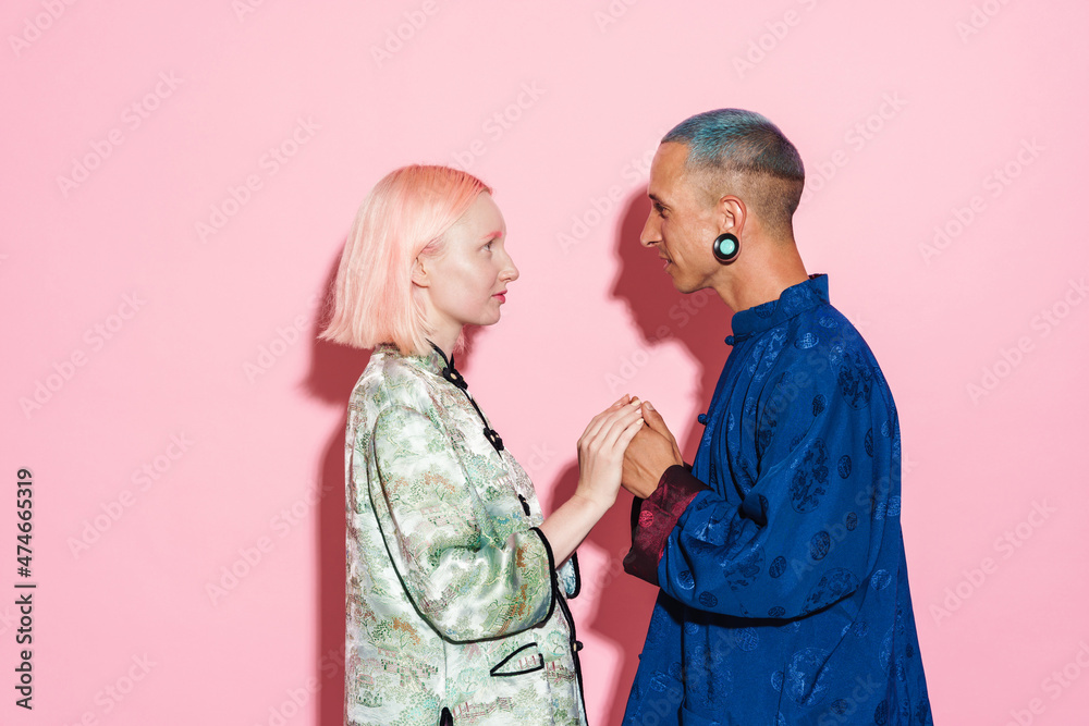 Young white couple in chinese jackets holding hands together Young white couple in chinese jackets holding hands together