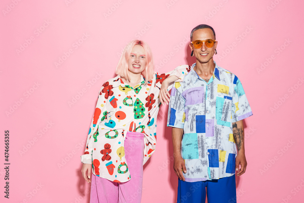 Young white couple in multicolored shirts smiling at camera