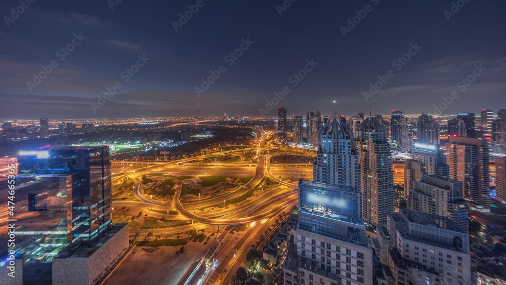 Fototapeta premium Huge highway crossroad junction between JLT district and Dubai Marina night to day timelapse.