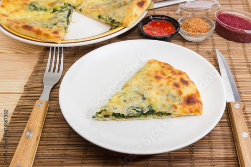 Serving of khachapuri on dish on a bamboo place mat
