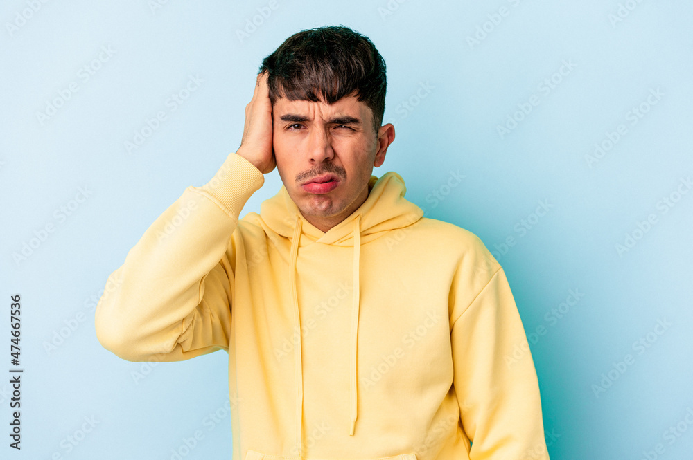 Young mixed race man isolated on blue background tired and very sleepy keeping hand on head. Young mixed race man isolated on blue background tired and very sleepy keeping hand on head.
