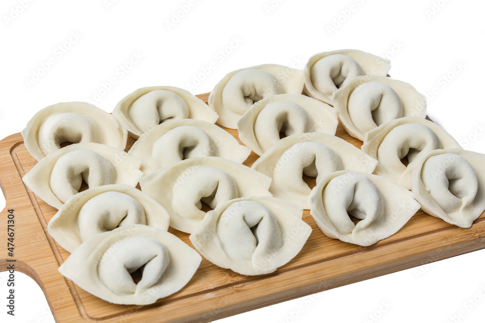 The process of making home-made dumplings. Raw homemade dumplings on a wooden board. Molding dumplings. The process of making home-made dumplings. Raw homemade dumplings on a wooden board. Molding dumplings.
