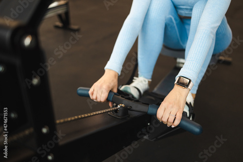 Woman in blue sportswear working out on a rowing machine