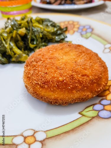 Pane tagliato in forma rotonda, ripieno di formaggio, impanato e fritto con contorno di verdure photo