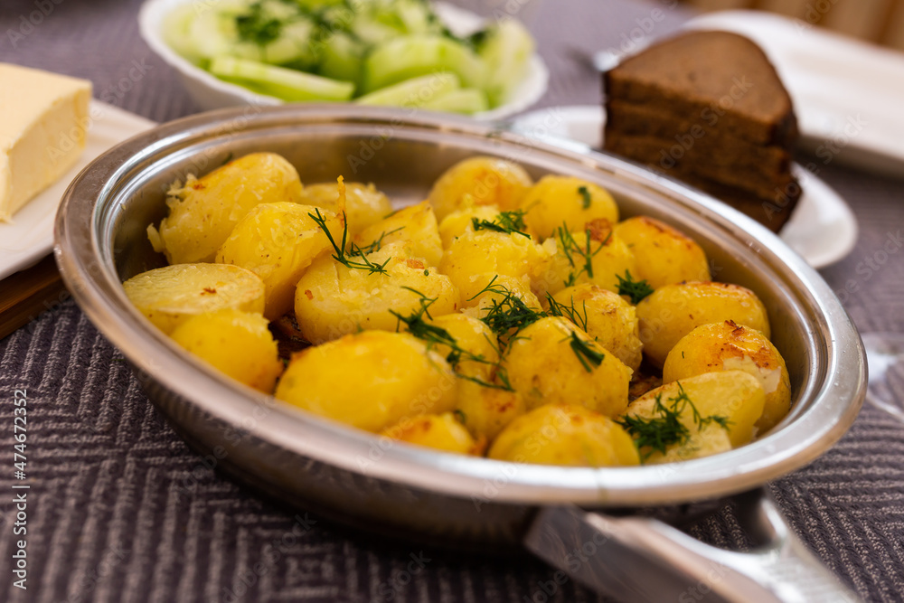 toasted young potatoes with dill in metal skillet