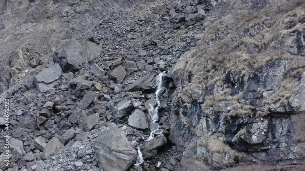 Drone flying away from rapid stream of mountain waterfall in autumn day Drone flying away from rapid stream of mountain waterfall in autumn day