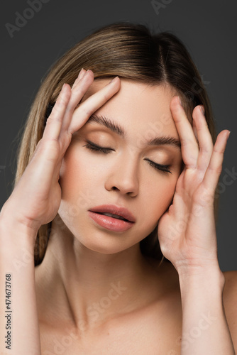 Wallpaper Mural young woman with closed eyes and natural makeup touching face isolated on grey Torontodigital.ca