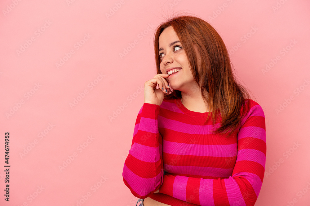 Young caucasian woman isolated on pink background relaxed thinking about something looking at a copy space. Young caucasian woman isolated on pink background relaxed thinking about something looking at a copy space.