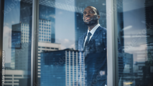 Cuadro en lienzo Thoughtful African-American Businessman in a Perfect Tailored Suit Standing in His Office Looking out of the Window on Big City