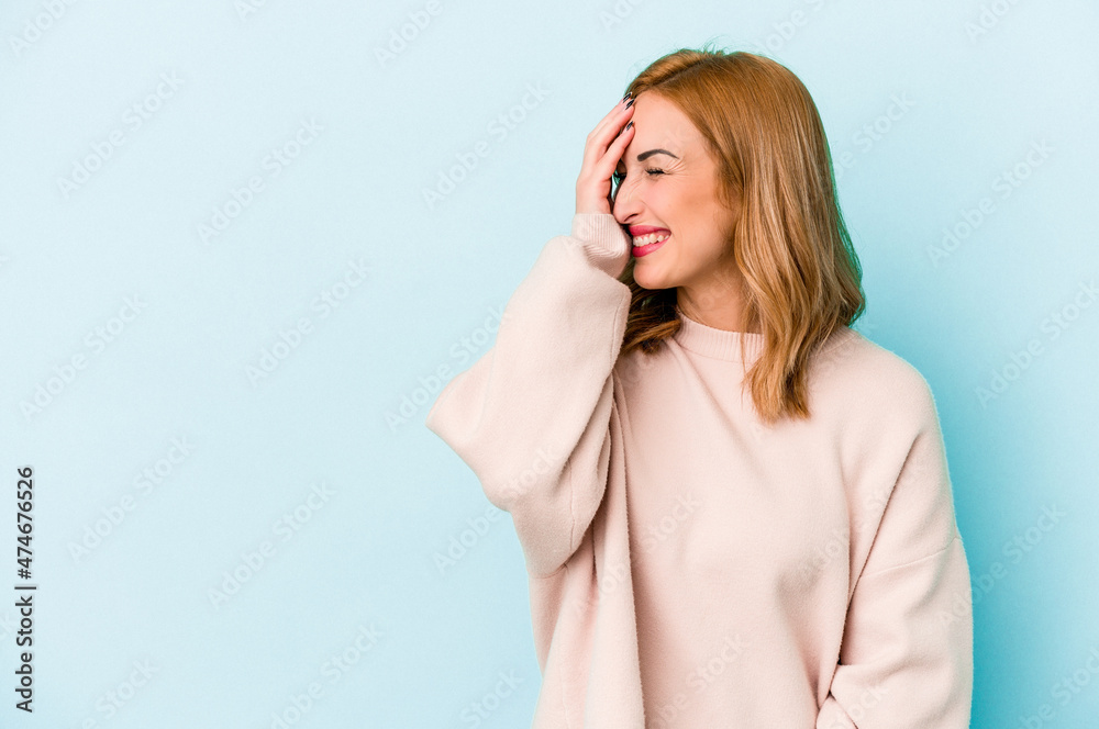 Young caucasian woman isolated on blue background laughing happy, carefree, natural emotion. Young caucasian woman isolated on blue background laughing happy, carefree, natural emotion.
