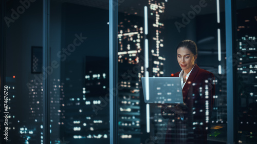 Successful Businesswoman in Stylish Suit Working, on Laptop Looking in Wonder at Night City. Stylish Beautiful Female CEO Working Late on Computer to Achieve Best Results. Colorful Portrait
