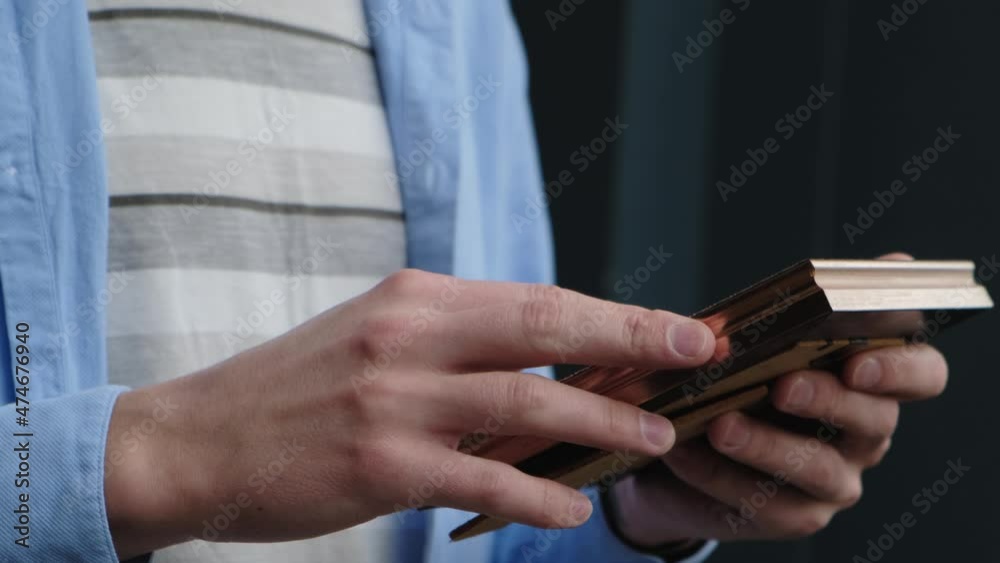 Unrecognizable, a man holds a framed photo in his hands and gently strokes the frame Unrecognizable, a man holds a framed photo in his hands and gently strokes the frame
