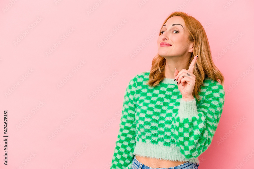 Young caucasian woman isolated on pink background showing number one with finger. Young caucasian woman isolated on pink background showing number one with finger.